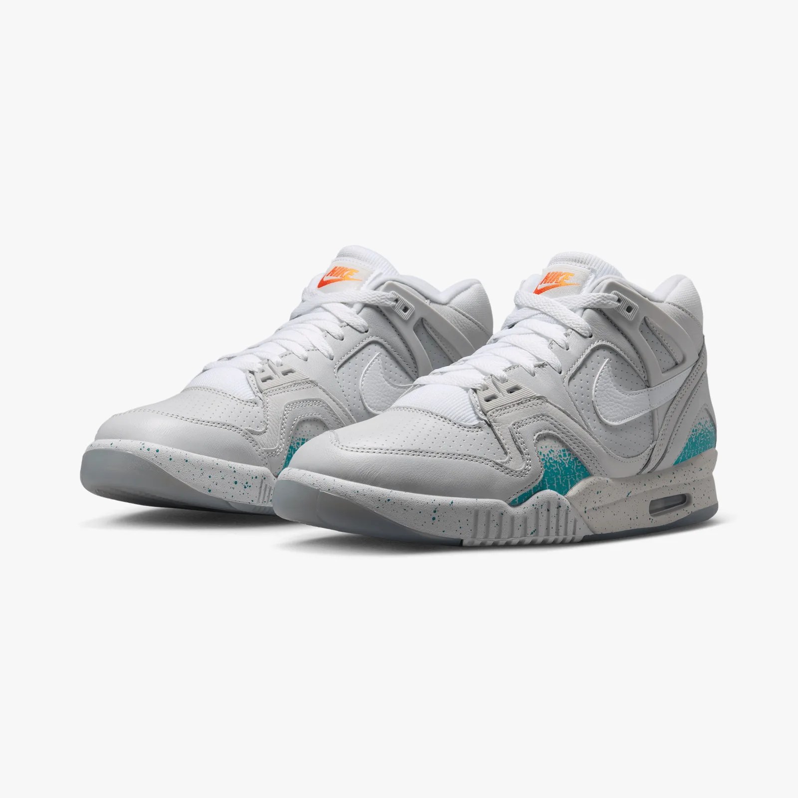 Pair of white Nike sneakers with teal speckled accents on the midsole and orange Nike logo on the tongue.