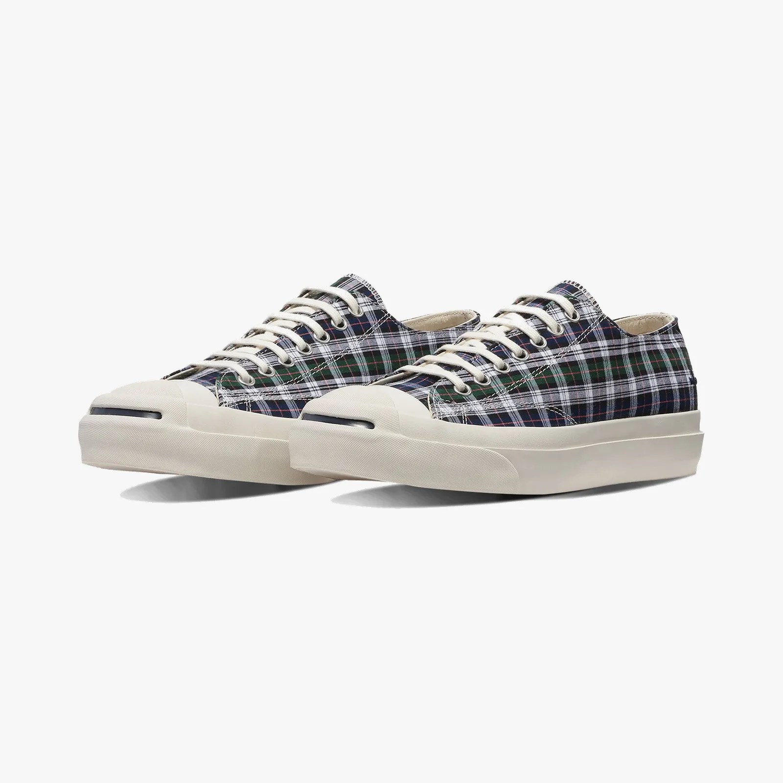 Pair of low-top sneakers with green, navy, and white plaid canvas uppers and off-white rubber soles and toe caps.