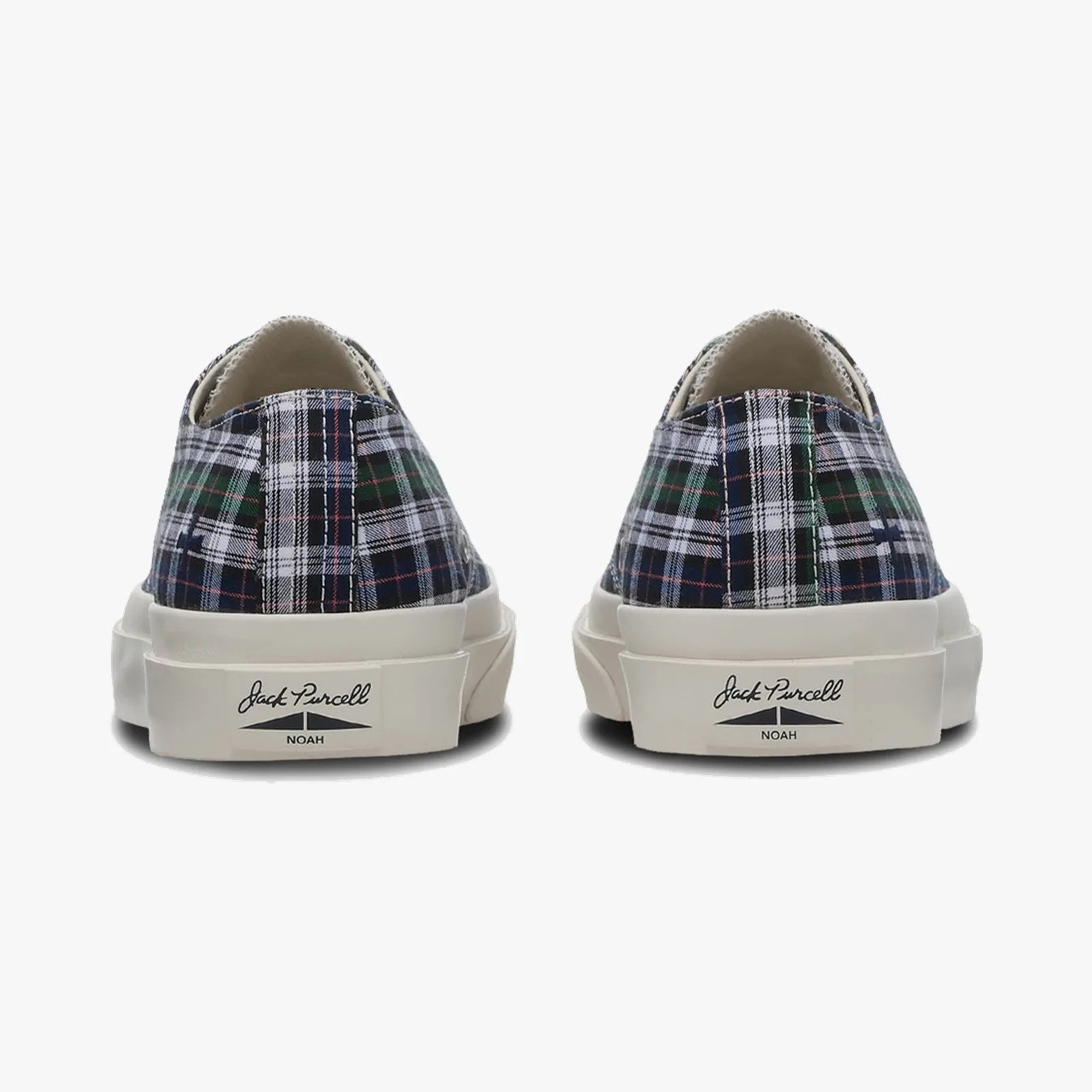 Pair of low-top sneakers with navy, green, and white plaid fabric uppers and white rubber soles labeled "Jack Purcell NOAH.