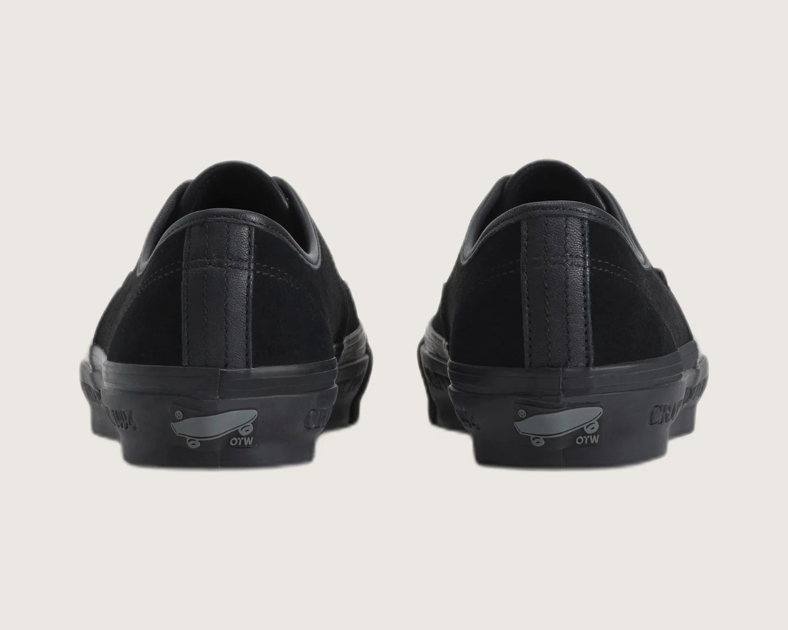 Pair of black low-top sneakers with suede and leather details, viewed from the back.