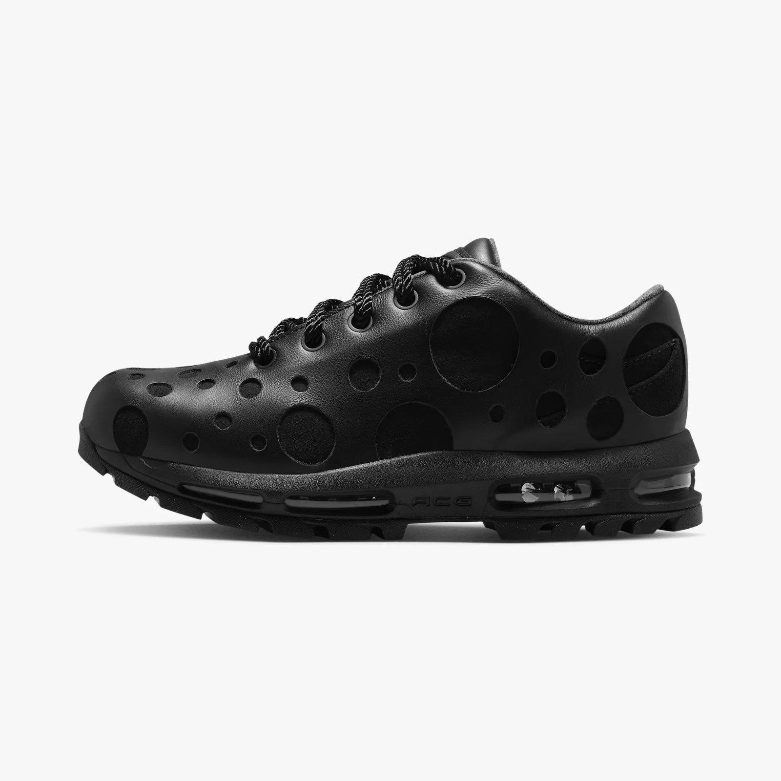 Black sneaker with circular cutouts and visible air cushioning in the sole.