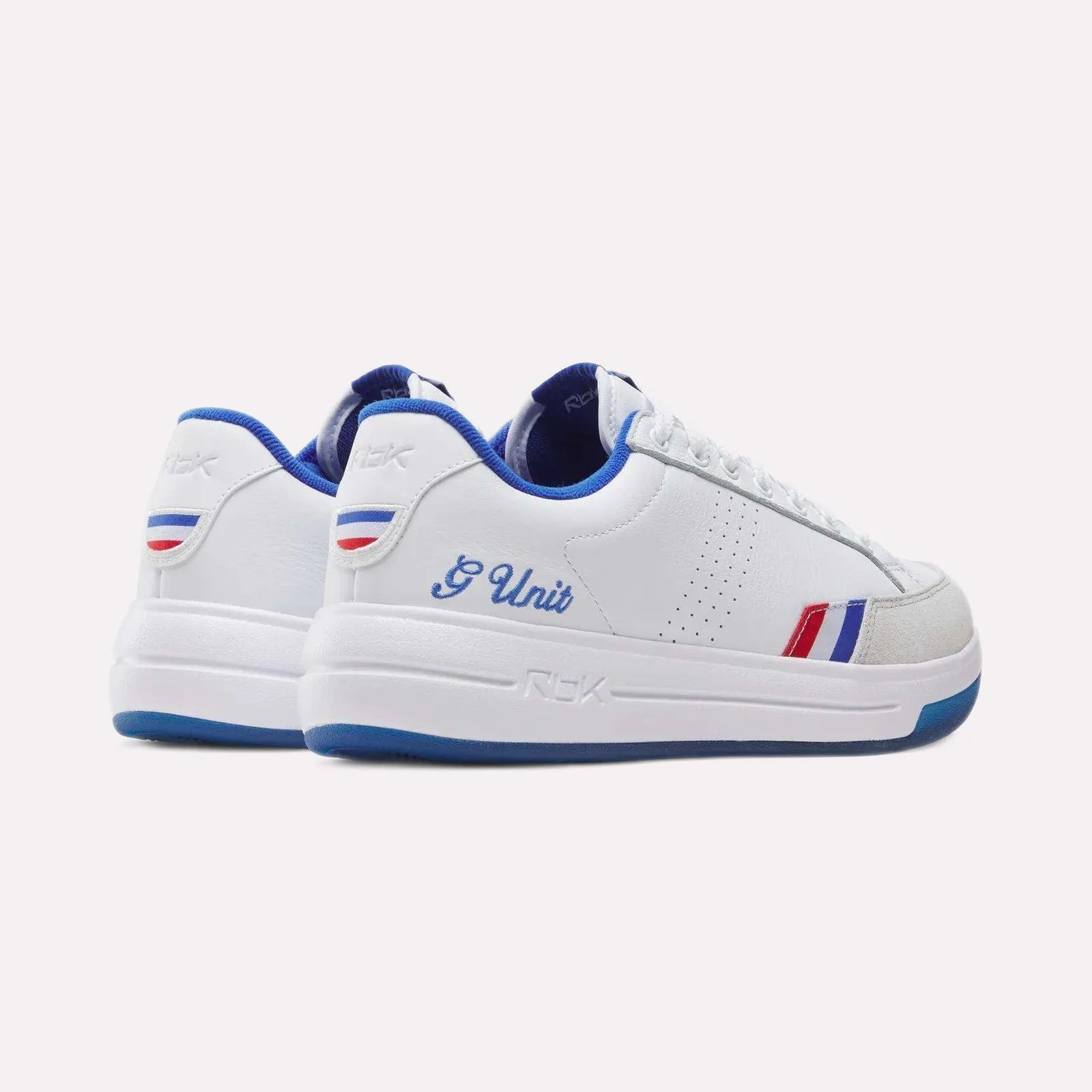 Pair of white low-top sneakers with blue lining, red and blue stripes, and "G Unit" embroidered on the side.